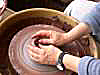 a student throwing on the potter's wheel