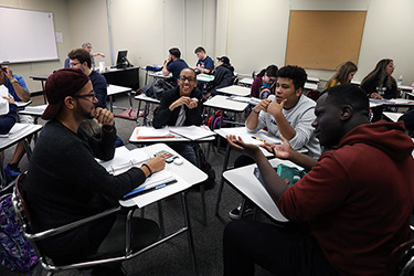 Students Chatting in Groups in Class