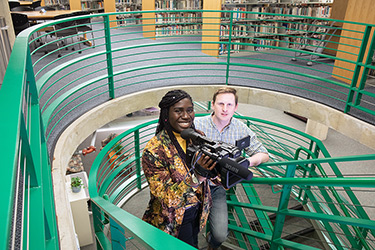 Students on stairs with professional videocamera
